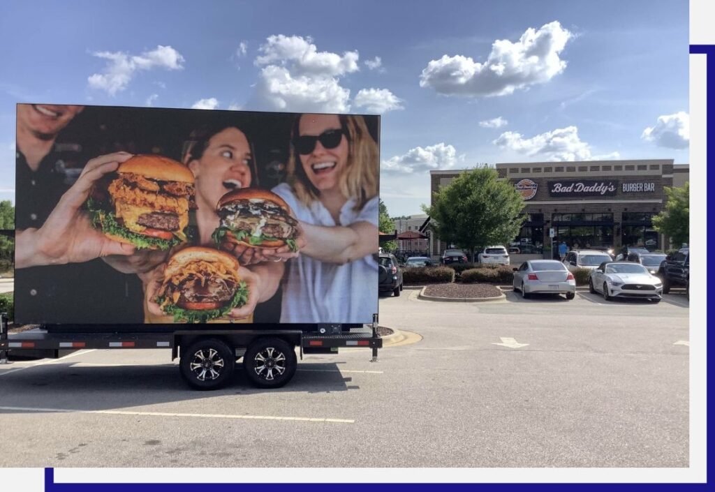 Picture of mobile billboard with image for a Bad Daddy's Burger on it